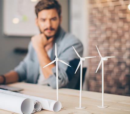 person looking at tiny windmill models